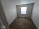 This bedroom features neutral walls, carpeted floors, and a window to let in natural light at 6114 Arrowhead Dr, Anderson, IN 46013