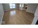 Sun-filled living room with beautiful wood-look flooring and a view into the kitchen at 6114 Arrowhead Dr, Anderson, IN 46013