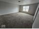 Spacious living room offering a large window and plush carpeting to provide comfort and natural light at 6114 Arrowhead Dr, Anderson, IN 46013