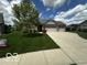 Attractive single-story home with a three-car garage, lush lawn, and beautiful landscaping features at 6117 Arctic Cir, Indianapolis, IN 46237