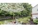 A fenced backyard with green grass, an outdoor table, a barbeque, and a leafy umbrella for shade at 6126 Golden Eagle Dr, Zionsville, IN 46077