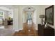 Inviting hallway with hardwood floors, arched doorways, and a view into the dining room at 6126 Golden Eagle Dr, Zionsville, IN 46077