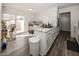 Bright kitchen boasts white cabinets, marble countertops, an island and wood flooring at 615 Conner Creek Dr, Fishers, IN 46038