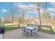 A wooden deck features a table and chairs, overlooking a lush backyard with mature trees and a well-manicured lawn at 6530 Grant Wood Ct, Indianapolis, IN 46256