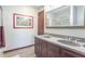 Bathroom features dual sinks with neutral countertops and a decorative mirror with a wood frame at 6530 Grant Wood Ct, Indianapolis, IN 46256