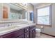 This bathroom includes dual sinks, a decorative mirror, and a window for natural light at 6530 Grant Wood Ct, Indianapolis, IN 46256