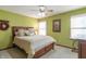 Well-lit bedroom with neutral carpet, a ceiling fan with a light, and bright green walls at 6530 Grant Wood Ct, Indianapolis, IN 46256