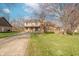 Beautifully landscaped two-story home with a brick facade, covered porch, and a blue garage door at 6530 Grant Wood Ct, Indianapolis, IN 46256