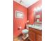 Cozy powder room with red walls, a framed mirror, and decorative accents at 6530 Grant Wood Ct, Indianapolis, IN 46256