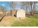 A backyard storage shed offers practical space for tools and equipment, set against a backdrop of mature trees and sky at 6530 Grant Wood Ct, Indianapolis, IN 46256