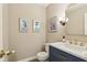 Elegant half bath with a blue vanity, gold hardware, a marble countertop, and modern fixtures at 6878 Black Oak East Ct, Avon, IN 46123