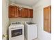 Functional laundry room with matching washer and dryer, upper cabinets, and neutral paint at 6878 Black Oak East Ct, Avon, IN 46123