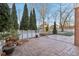 Stone patio area with evergreen trees and a white fence around the backyard at 6878 Black Oak East Ct, Avon, IN 46123