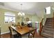 Well-lit dining room showcasing hardwood floors, a chandelier, and a view of the staircase at 700 Greenford N Trl, Carmel, IN 46032