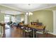 Open-concept dining and living room featuring hardwood floors, green walls, and stylish furniture at 700 Greenford N Trl, Carmel, IN 46032