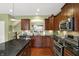 Kitchen with granite counters, stainless steel appliances, island, and dark wood cabinets at 700 Greenford N Trl, Carmel, IN 46032