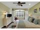 Bright main bedroom with an archway to a seating area, a ceiling fan, and neutral décor at 700 Greenford N Trl, Carmel, IN 46032