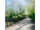 Scenic asphalt walking path surrounded by lush trees and a black metal fence, ideal for leisurely strolls at 700 Greenford N Trl, Carmel, IN 46032