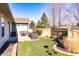 A patio area is adjoined to a fenced backyard featuring a variety of trees and foliage at 7221 Broyles Ln, Indianapolis, IN 46217