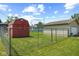 Spacious backyard with a chain-link fence, red shed, and detached garage at 817 Hamilton St, Lebanon, IN 46052