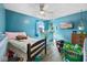 Bright bedroom featuring blue walls, a ceiling fan, and natural light from the window at 817 Hamilton St, Lebanon, IN 46052