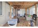 Covered wooden patio with a hammock, chair, and natural lighting, creating a relaxed outdoor space at 817 Hamilton St, Lebanon, IN 46052