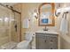 Updated bathroom featuring tiled walk-in shower and vanity with decorative sconces and neutral color palette at 8401 N College Ave, Indianapolis, IN 46240