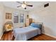Bedroom with hardwood floors, ceiling fan with crystal embellishments, a decorative chair, and bright natural light at 8401 N College Ave, Indianapolis, IN 46240