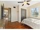 Bedroom with hardwood floors, large closet, and a ceiling fan with light, adjoined to an open doorway at 8401 N College Ave, Indianapolis, IN 46240