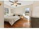 Sunlit bedroom with hardwood floors, ceiling fan with crystal embellishments, and light neutral walls at 8401 N College Ave, Indianapolis, IN 46240
