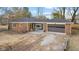 Aerial view of a charming brick home showcasing a yellow door, a detached garage, and a well-maintained yard at 8401 N College Ave, Indianapolis, IN 46240