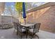 Brick patio with a dining table, six chairs, and a blue umbrella surrounded by mature trees at 8401 N College Ave, Indianapolis, IN 46240