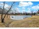Scenic view of a neighborhood pond; surrounded by trees, grass and a blue sky at 897 Copperwood Dr, Carmel, IN 46033