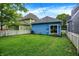 Spacious backyard with a lush lawn, white picket fence, blue siding, green siding, and mature trees at 912 Harlan St, Indianapolis, IN 46203