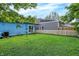 View of a spacious backyard featuring well-kept lawn, a white picket fence, and a two-toned house at 912 Harlan St, Indianapolis, IN 46203