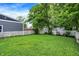 The large backyard offers a well-maintained lawn and a classic white picket fence for privacy at 912 Harlan St, Indianapolis, IN 46203
