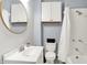 Cozy bathroom with a tub and shower, vanity, commode, and mirrored cabinet above the commode at 912 Harlan St, Indianapolis, IN 46203