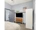 Bedroom with hardwood floors featuring modern TV console, floating shelf, and view into the adjacent room at 912 Harlan St, Indianapolis, IN 46203