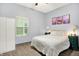 Bright bedroom features a large window, closet, and a bed with fluffy comforter flanked by green nightstands at 912 Harlan St, Indianapolis, IN 46203