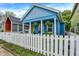 Charming blue home featuring a white picket fence, cozy front porch, and well-maintained landscaping at 912 Harlan St, Indianapolis, IN 46203