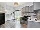 Well-lit kitchen features stainless steel appliances, grey cabinets, and a view of the backyard at 912 Harlan St, Indianapolis, IN 46203