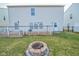 The property's backyard, featuring a wood deck, fire pit, green lawn, and the home's neutral-toned siding at 10708 Inspiration Dr, Indianapolis, IN 46259