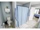 Bathroom featuring a toilet, sink, and a shower with a blue curtain at 10708 Inspiration Dr, Indianapolis, IN 46259