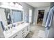 Bathroom with a double vanity, large mirror, and a view of the closet at 10708 Inspiration Dr, Indianapolis, IN 46259
