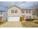 Charming two-story home featuring a two car garage, landscaped yard, and vibrant red shutters and front door at 10708 Inspiration Dr, Indianapolis, IN 46259
