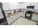 Bright kitchen with stainless steel appliances, white cabinets, and tile flooring at 10708 Inspiration Dr, Indianapolis, IN 46259
