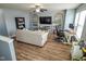 Bright living room with a ceiling fan, hardwood floors, and natural light filtering through the windows at 10708 Inspiration Dr, Indianapolis, IN 46259