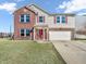 Inviting two-story home featuring a brick facade, vinyl siding, attached garage and a well-manicured lawn at 10830 Clear Spring Dr, Camby, IN 46113