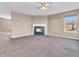 Comfortable living room with a cozy fireplace, ceiling fan, plush carpeting and neutral paint at 10830 Clear Spring Dr, Camby, IN 46113