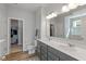 Bright bathroom with a double vanity, gray cabinets, white countertop, and a walk-in closet at 10865 Mystic View Ct, Indianapolis, IN 46239